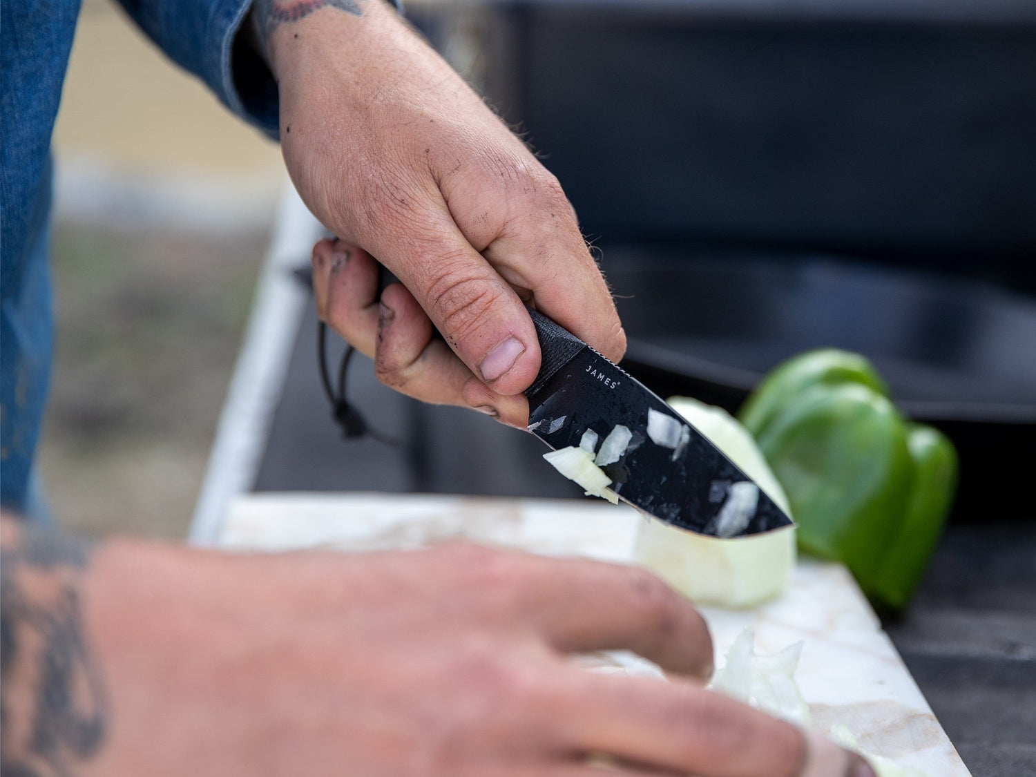 A man cutting onions with his Hell Gap fixed blade camping knife.