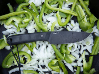 The Hell Gap fixed blade camping knife on a pile of cut vegetables.