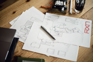 The Bolen titanium EDC twist pen on a desk with sketches.