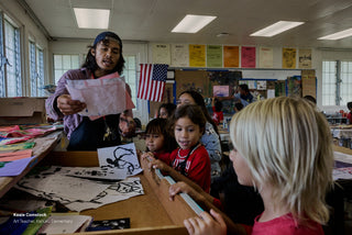 The art teacher of Kahuku elementary school working with students.