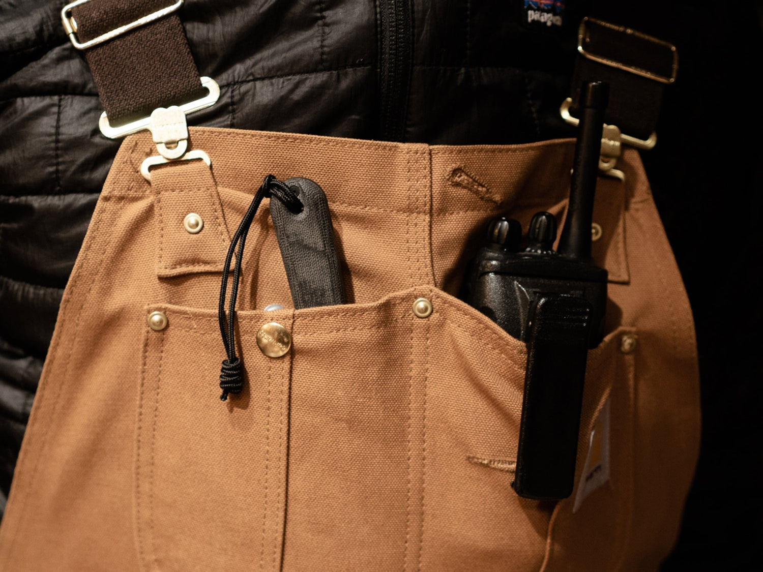 The Hell Gap fixed blade camping knife being carried in it's sheath in an overalls pocket.