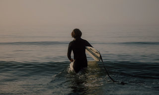 A surfer headed into the waves of the North Sea in Germany.
