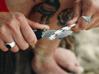 A man slicing through rope with his Carter EDC folding pocket knife.