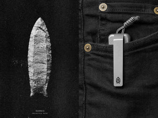 A Barnes arrow projectile point being shown next to a Barnes integral EDC titanium folding frame lock pocket knife in pocket.