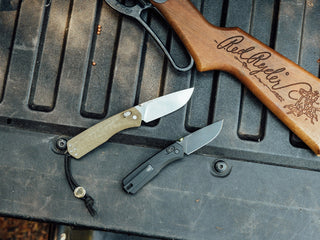 Two Carter EDC folding slide lock pocket knives on a truck bed in two sizes.