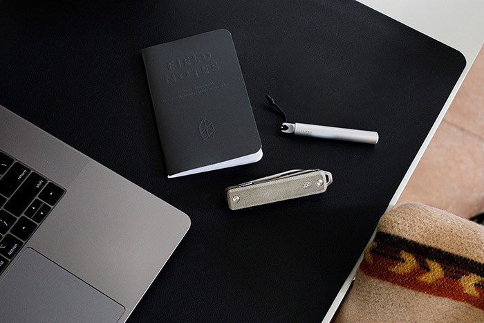 The Ellis EDC multitool and Stilwell compact pen on a desktop with a Field Notes notebook.