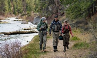 Three people going fishing on a river.