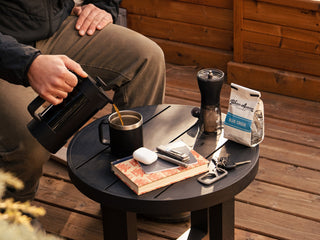 The Mehlville EDC keychain carabiner with keys attached on a table as a man pours coffee.