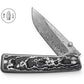 The Barnes integral titanium pocket knife with snow carbon scales and a Damasteel blade.