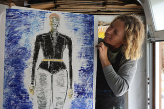 An artist holding up a fresh print.