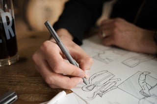 A person sketching with The Bolen titanium EDC twist pen.