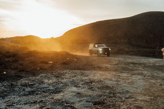 The sun setting over dusty dirt roads in Baja California.