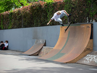 Artist and skateboarder Sebo Walker kick flipping on a quarter pipe.