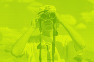 A green graphic with a man with binoculars.